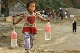 Čínská dívka nese do vesnice vodu z horského potoka.
